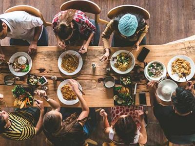 Menschen sitzen am Tisch und essen