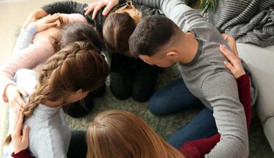Gruppe junger Menschen betet zusammen