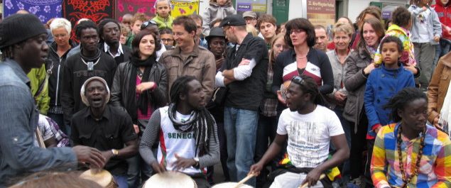 Afrikaner spielen vor Menschenmenge mit Trommeln