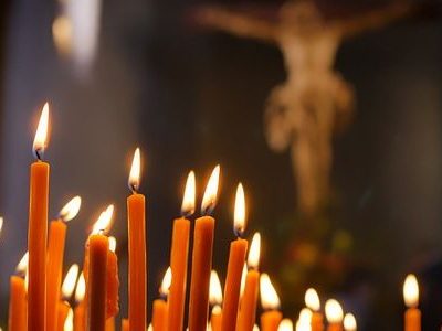 Kerzen vor einem Kreuz in einer Kirche