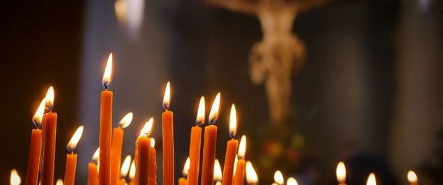 Kerzen vor einem Kreuz in einer Kirche