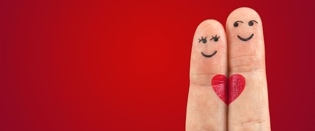 Zwei Finger, auf die Gesichter gemalt sind. Über beide Finger hinweg ist ein Herz zu sehen.
