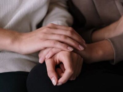 Eine Person hält die Hand einer anderen.