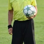 Ein Schiedsrichter, der einen Ball hält.