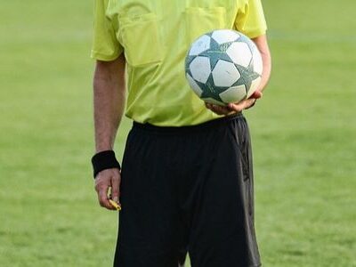 Ein Schiedsrichter, der einen Ball hält.