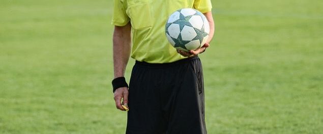 Ein Schiedsrichter, der einen Ball hält.